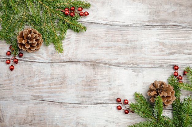 Fond de Noël avec des branches de sapin, des baies et des cônes