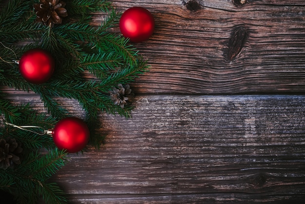 Fond de Noël avec des branches de sapin, des boules rouges et des pommes de pin. Décor d'hiver traditionnel