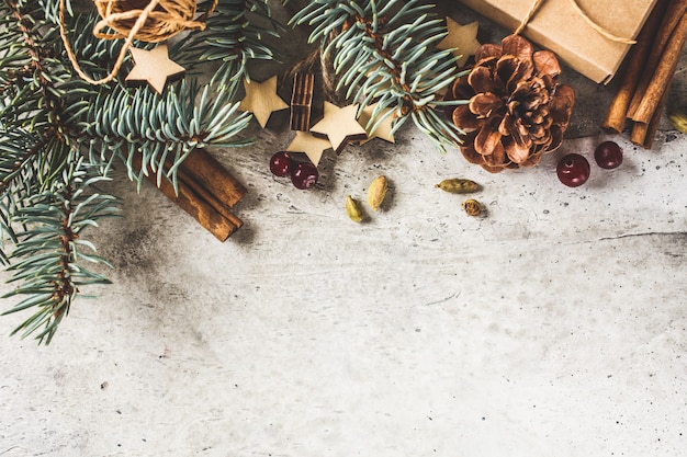 Fond de Noël avec des branches de sapin, des cônes, de la cannelle et des cadeaux