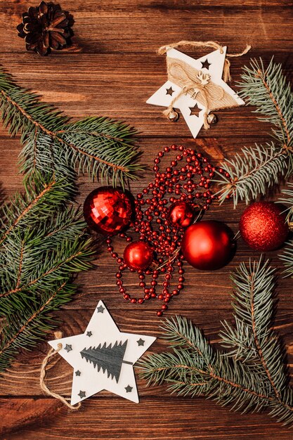 Fond de Noël avec brin de sapin et jouets rouges sur des planches en bois.