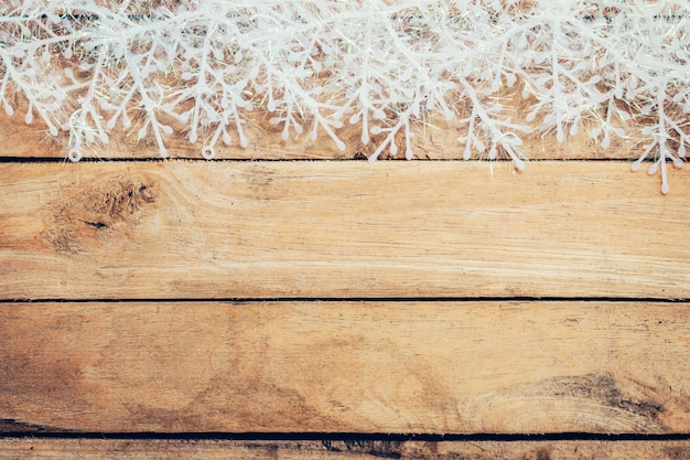 Photo fond de noël brun en bois et flocons de neige avec de l'espace.