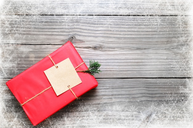 Fond de Noël - Cadeau de Noël boîte de cadeaux rouge sur fond de bois vintage avec un flocon de neige. Composition créative de la disposition plate et de la vue de dessus avec la conception de bordure et d&#39;espace de copie.