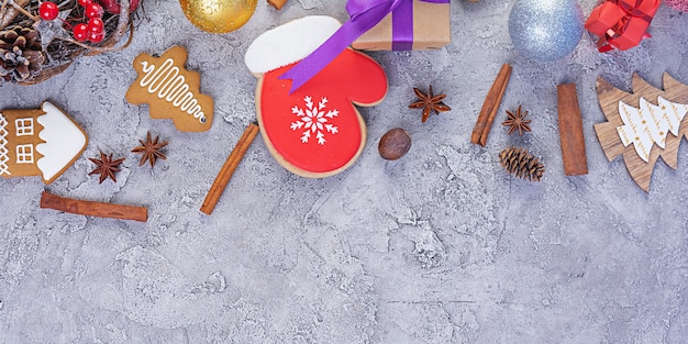 Fond de Noël. Cadeau de Noël, jouets, biscuits de pain d'épice, épices et décorations sur table en bois. Vue de dessus
