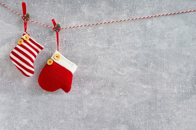 Fond de Noël Chaussettes et mitaines de Noël rouges sur fond gris