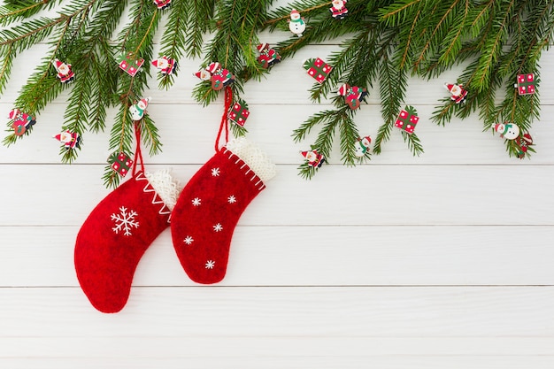 Fond de Noël Chaussettes de Noël rouges sur un fond en bois blanc avec sapin de Noël décoré. Espace de copie