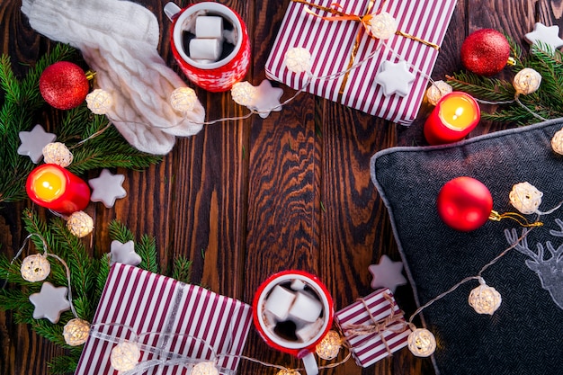 Fond de Noël avec coffrets cadeaux, chocolat chaud, branches de sapin et autres décorations