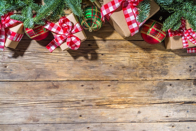 Fond de Noël avec des coffrets cadeaux fabriqués à la main, des branches de sapin et une boule d'arbre de Noël, espace de copie de fond en bois