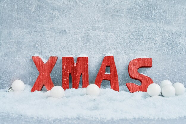 Fond de Noël. Décoration de Noël avec de la neige. Lettres rouges XMAS dans la neige. Copier cpace, vue de dessus.