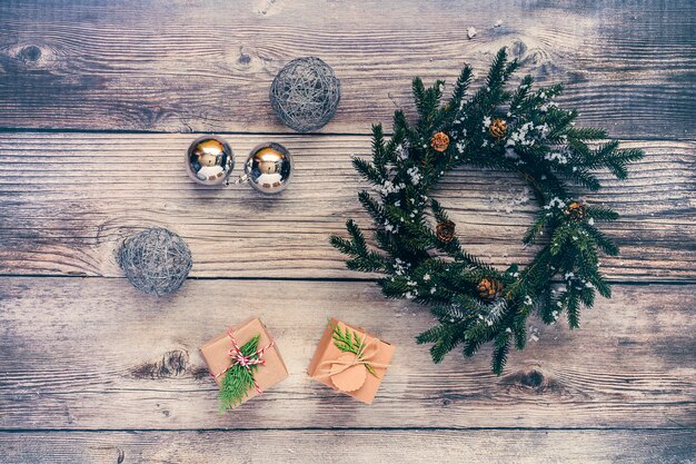 Fond de Noël avec décorations et coffrets cadeaux sur planche de bois.