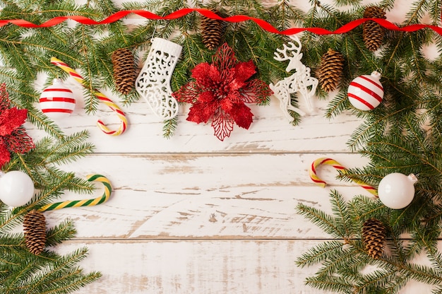 Fond de Noël avec des décorations de Noël traditionnelles - boules de verre, canne au caramel, fleur rouge sur fond de bois blanc. une copie de l'espace.