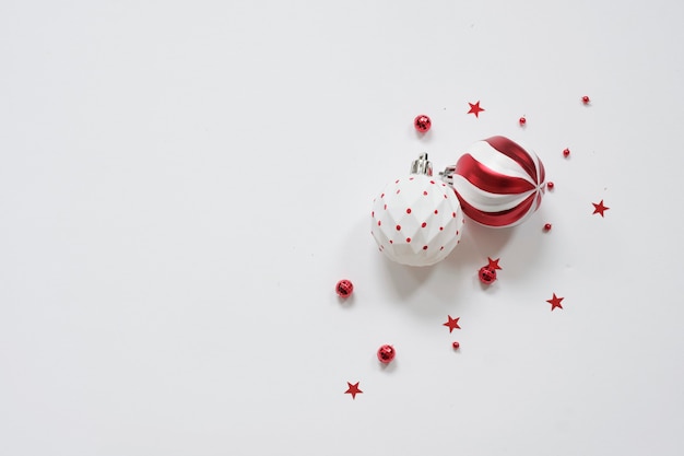 Photo fond de noël - décorations rouges sur table blanche. noël, hiver, concept de nouvel an. mise à plat, vue de dessus