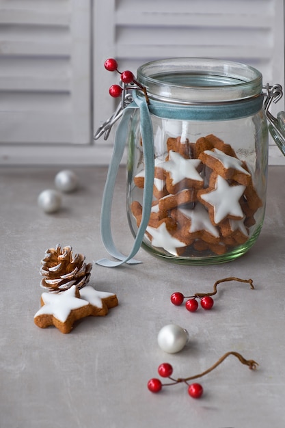 Fond de Noël avec de délicieux biscuits au gingembre étoilé dans un bocal en verre