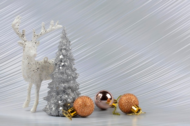 Fond de Noël ou du nouvel an avec arbre enneigé argenté et cerf de décoration transitionnel doré