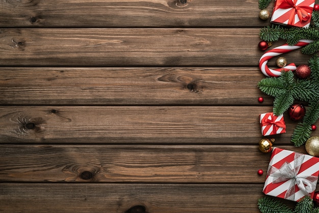 Photo fond de noël et du nouvel an avec une bordure décorative faite de boîte-cadeau et de branche de sapin. mise à plat, vue de dessus et espace de copie pour le texte