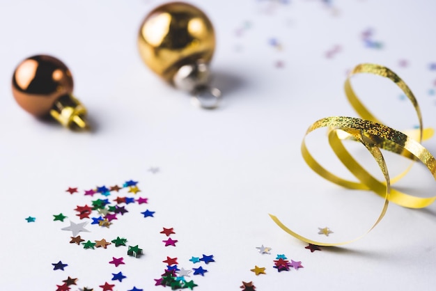 Fond de Noël ou du nouvel an avec des boules de Noël dorées et des confettis et fond bleu ruban