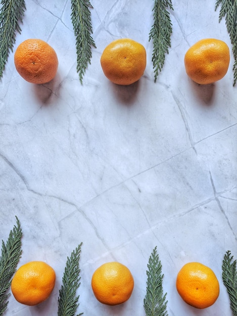 Fond de Noël et du nouvel an avec des branches de pin, des décorations et des mandarines fraîches orange. Appartement