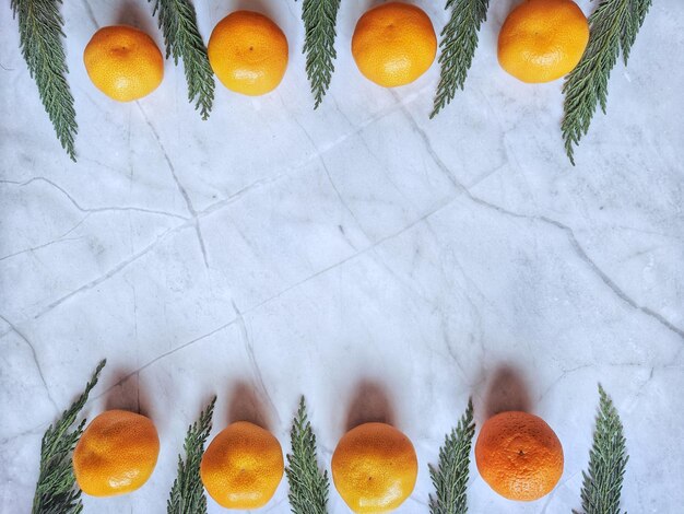 Fond de Noël et du nouvel an avec des branches de pin, des décorations et des mandarines fraîches orange. Appartement