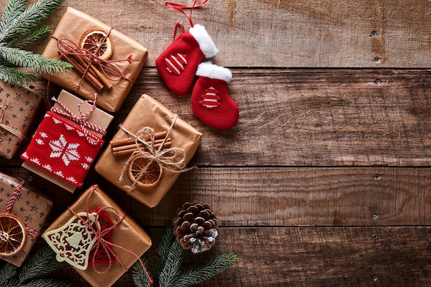 Fond de Noël ou du nouvel an avec des branches de sapin, des boules de Noël, une boîte-cadeau, des flocons de neige en bois et des étoiles sur fond de bois foncé. Place pour votre texte