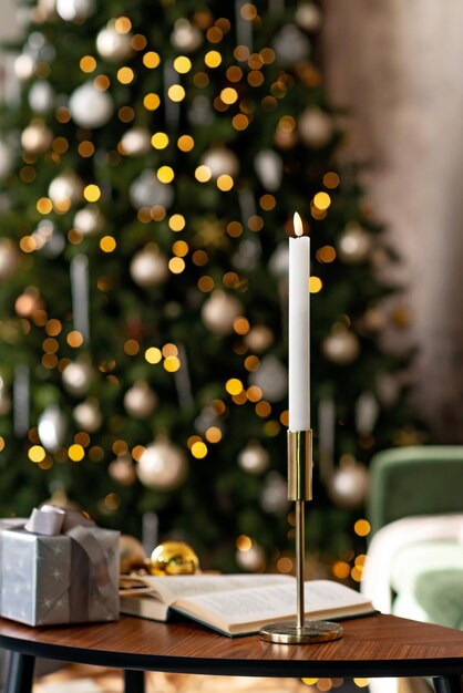 Fond de Noël et du nouvel an - coffrets cadeaux, cadeaux, bougies, sur fond de lumières floues d'un arbre de Noël décoré. Mise au point sélective douce.