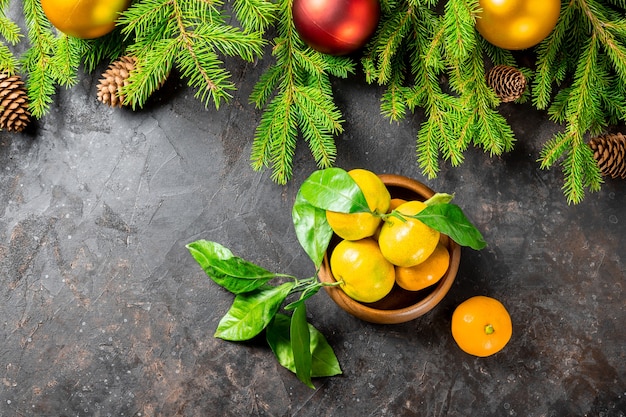 Fond de Noël ou du nouvel an avec sapin, décorations de Noël, bosses et mandarines