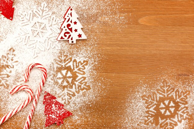 Photo fond de noël avec des flocons de neige de bonbons et un arbre de noël décoratif sur une table en bois