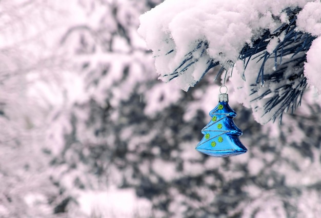 Fond de Noël avec un jouet de Noël sur une branche de pin enneigé avec un espace de copie