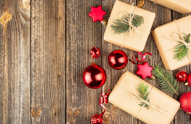 Fond de Noël avec des jouets rouges, des décorations, des coffrets cadeaux sur une table en bois. Copiez l'espace.