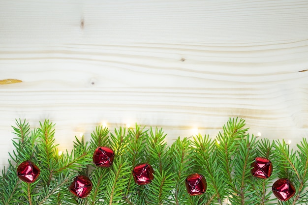 Fond de Noël avec des lumières de cloches rouges et bois