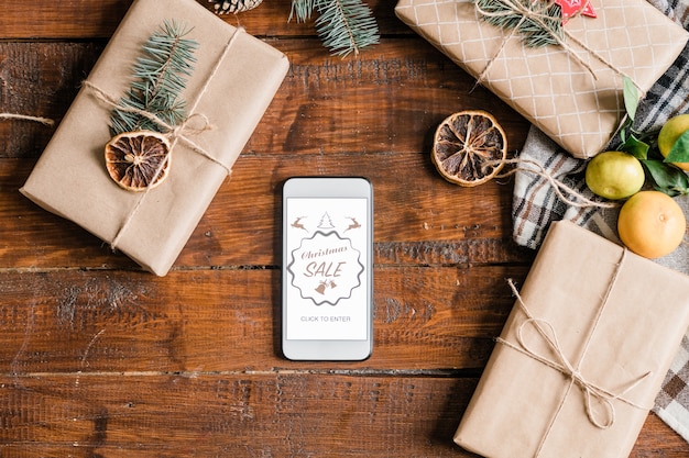 Fond de Noël avec page d'accueil de la boutique en ligne sur l'écran du smartphone, boîtes et clémentines emballées et emballées