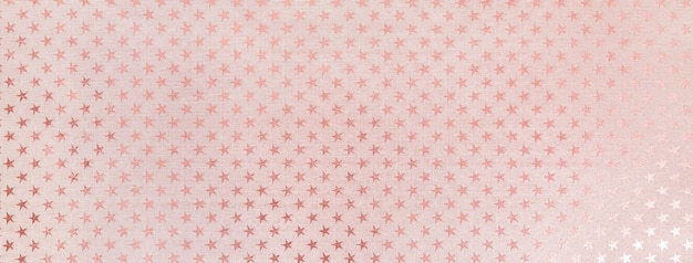 Fond de noël rose clair à partir de papier d'aluminium avec un motif d'étoiles scintillantes macro toile de fond rose pastel