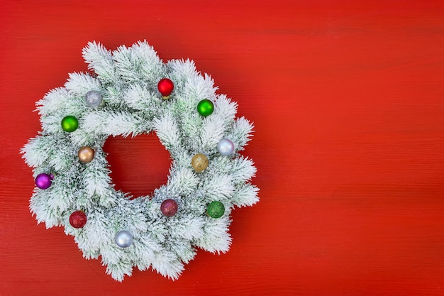 Fond de Noël rouge. Couronne de Noël blanche avec des ornements de Noël sur fond rouge. Vue de dessus, espace de copie