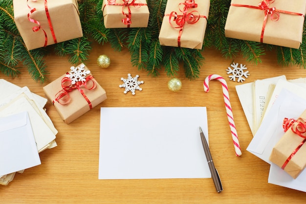 Fond de Noël avec des sacs-cadeaux et un cahier vierge entouré de décorations de Noël.