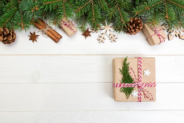 Fond de Noël avec sapin et coffret cadeau sur une table en bois. Vue de dessus avec fond