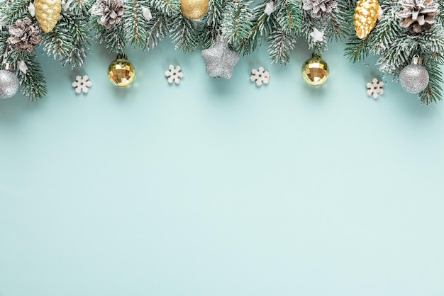 Fond de Noël avec sapin enneigé avec des décorations dorées et argentées sur fond bleu. Mise à plat. Vue de dessus avec espace de copie. Fond de fête