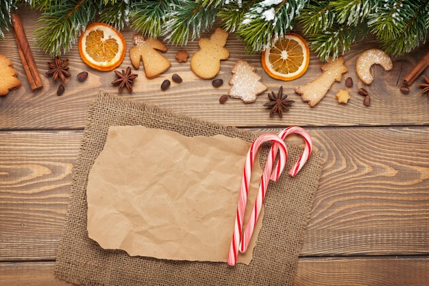 Fond de noël avec sapin de neige épices biscuits de pain d'épice et papier