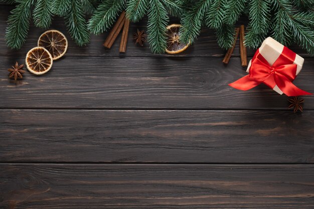 Fond de Noël. Sapin de Noël avec décoration et boîte-cadeau sur planche de bois sombre. Mise à plat. Copiez l'espace.