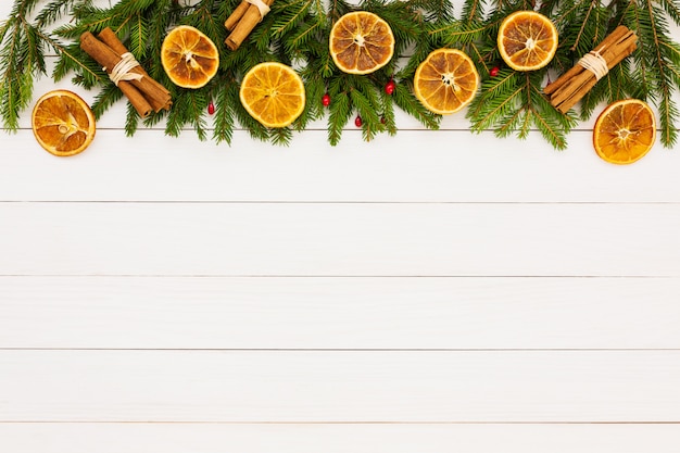 Fond de Noël Sapin de Noël, oranges séchées sur un fond en bois blanc avec espace de copie.