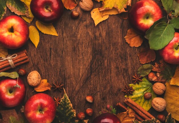 Fond de nourriture d'automne Pommes mûres avec des noix, des feuilles tombées et de la cannelle sur une table en bois rustique Vue de dessus Espace de copie