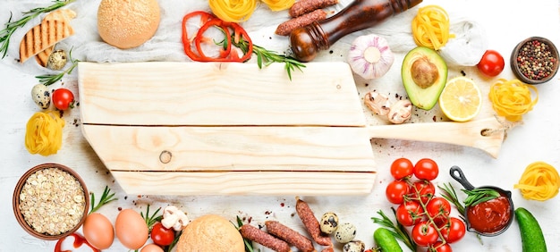 Fond de nourriture en bois blanc tomates pâtes épices légumes et saucisses vue de dessus