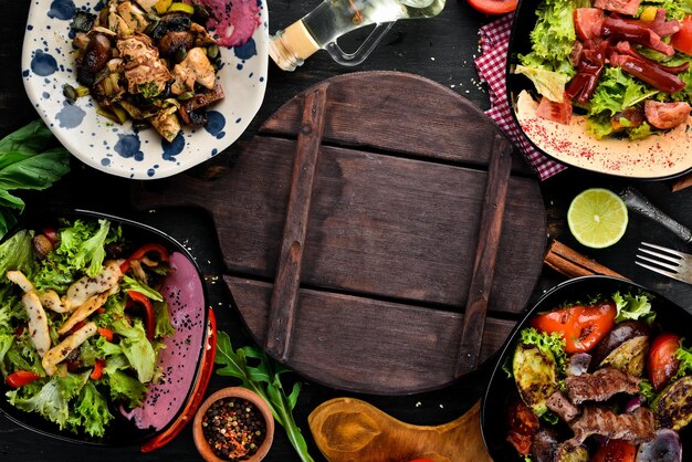 Fond de nourriture et de plats Plats de viande et de poisson et salade Sur un fond en bois Vue de dessus Espace libre pour votre texte