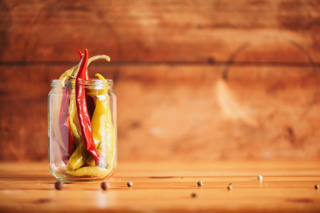 Fond de nourriture probiotiques Piment piment mariné dans des bocaux en verre sur fond blanc en bois Espace de copie