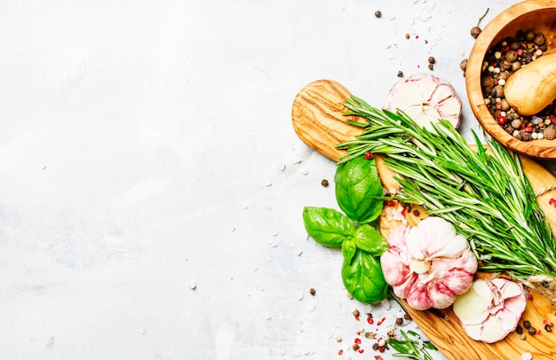 Fond de nourriture romarin frais basilic vert ail poivre sur une vue de dessus de planche à découper
