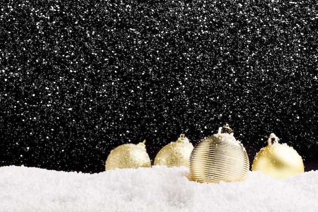 Fond de nouvel an avec des boules d'or et de la neige, espace de copie