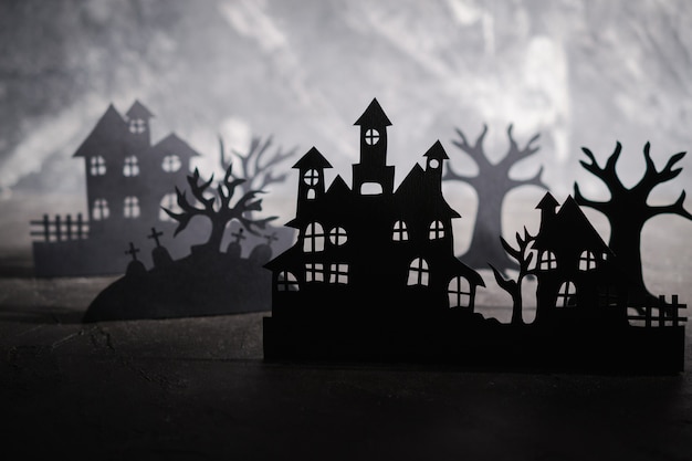 Photo fond de nuit d'halloween. l'art du papier. village abandonné dans une sombre forêt brumeuse