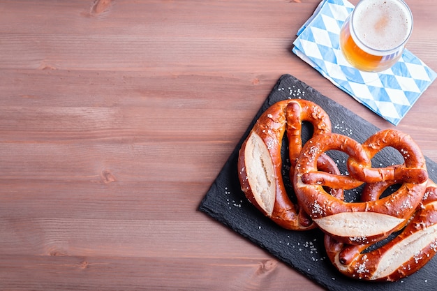 Fond d'Oktoberfest avec bière et bretzels et décor bavarois traditionnel en gros plan sur une table en bois, espace pour copie