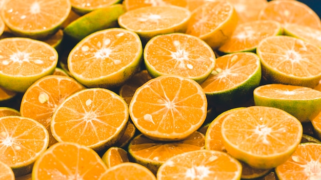 Photo fond orange en tranches. tranches d'agrumes oranges colorées. demi fruit orange , frais et juteux . alimentation saine et vitamine c
