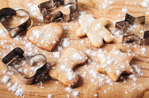 Fond de pains d'épice et d'emporte-piècesConcept de cuisine et de vacancesTable en bois