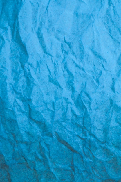 Fond de papier froissé bleu.