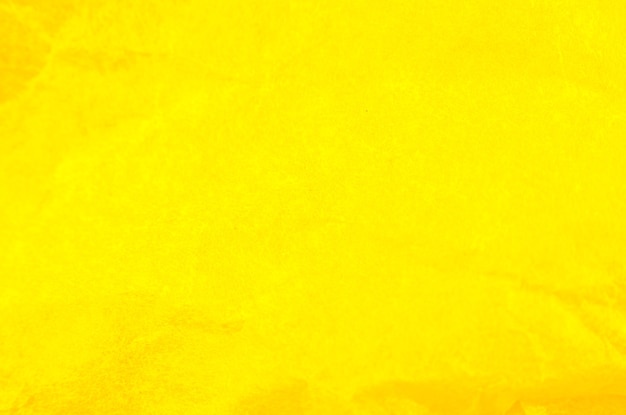 Fond de papier jaune froissé. Véritable texture macro battue. Gros plan photo.