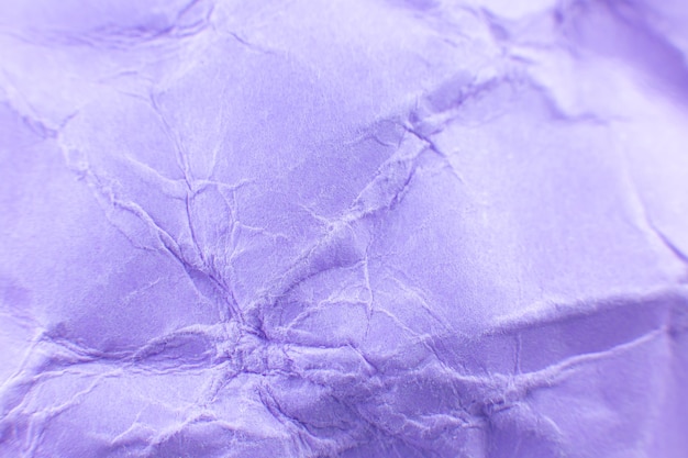 Fond de papier violet froissé. Véritable texture macro battue. Gros plan photo.